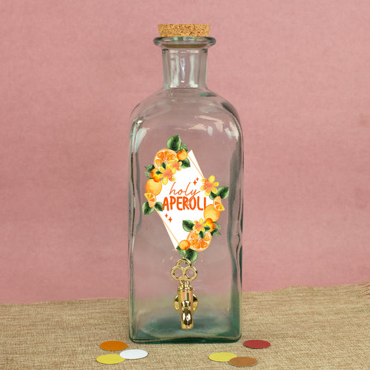 Glas Getränkespender mit Zapfhahn und sommerlichem Orangen-Motiv auf Stoffunterlage vor rosa Hintergrund
