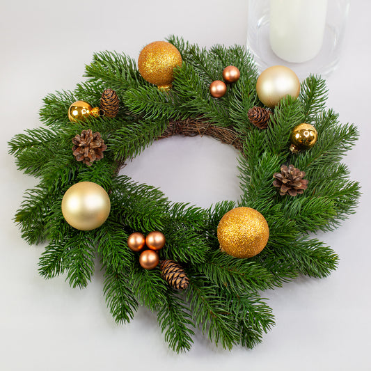 Kunst-Tannenkranz Ø 35 cm mit goldener Weihnachtsdeko und Kugeln auf Tisch