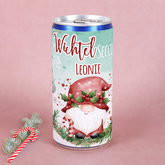 Wichtel Secco Dose mit Name Leonie, weihnachtlicher Wichtel mit Mistelzweigen und Zuckerstange, umgeben von winterlichen Elementen.
