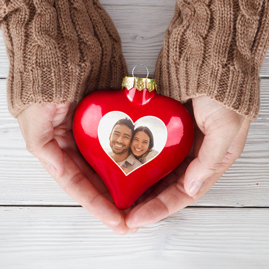 Personalisierte Weihnachtskugel in Herzform mit Foto eines lachenden Paares in Händen gehalten