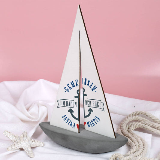 stilvolles Schiff mit bedrucktem Segel als Hochzeitsgeschenk mit Namen der Braut und des Bräutigams gemeinsam im Hafen der Ehe