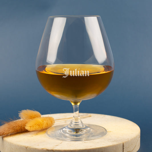 Leonardo Cognacglas mit Gravur „Julian“ in Frakturschrift – auf heller Scheibe mit blauer Hintergrundfarbe.