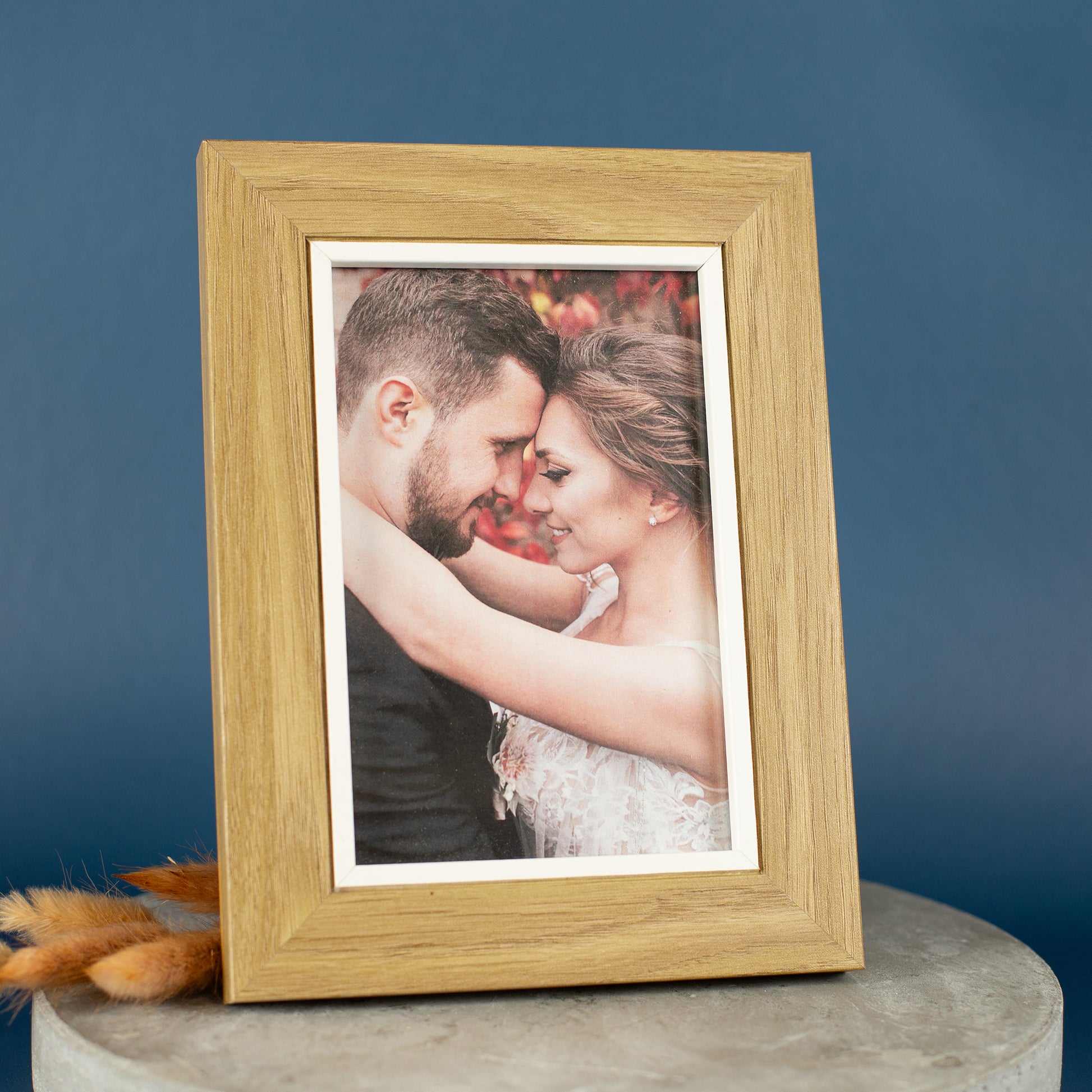 Bilderrahmen aus Holz mit weißem Innenrand auf blauem Hintergrund