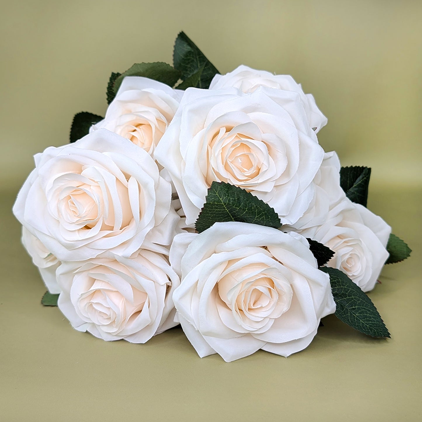 Nahaufnahme eines liegenden Rosenstraußes mit weißen Blüten auf grünem Hintergrund