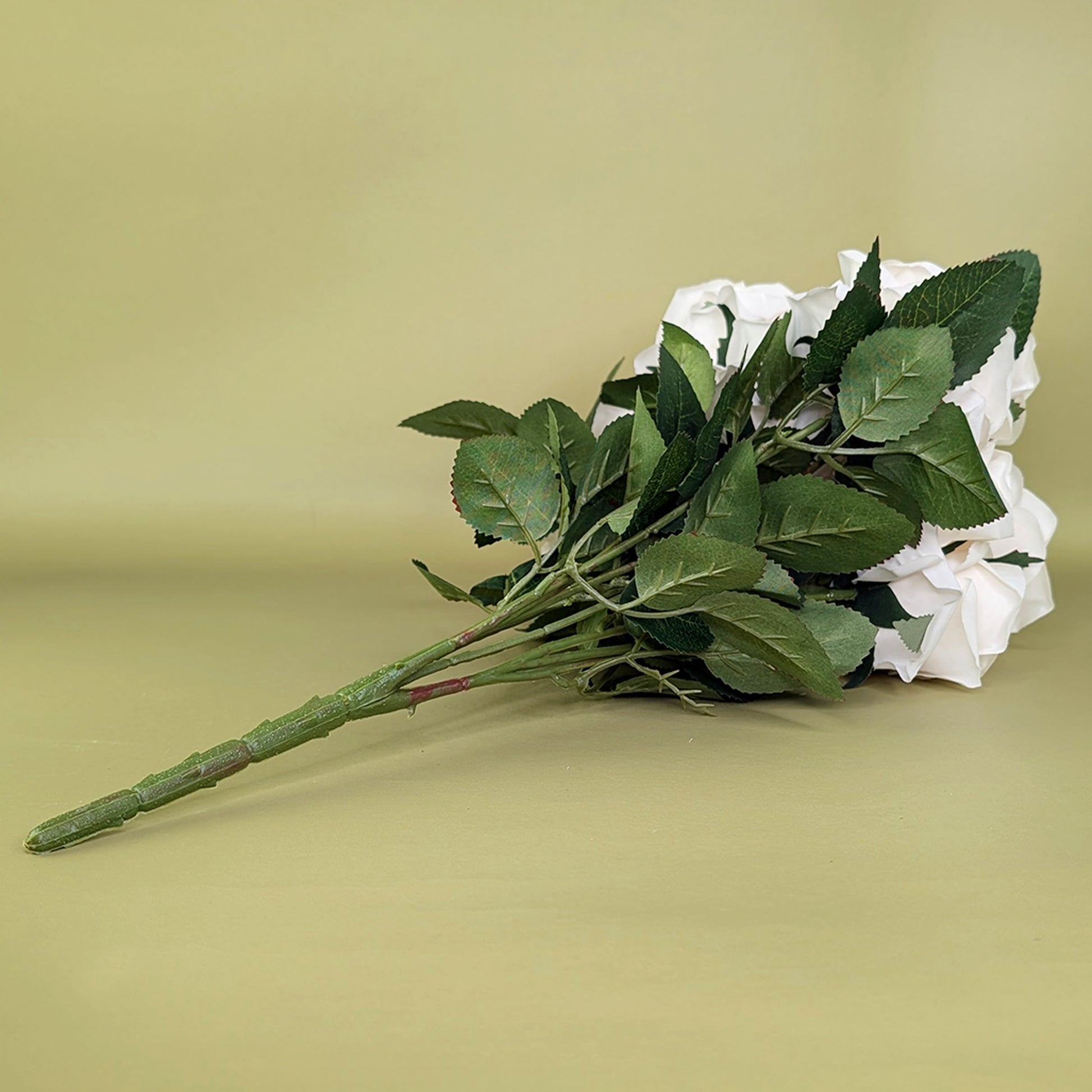 Rückansicht des Kunstrosenstraußes mit Fokus auf die grünen Blätter und Stiele