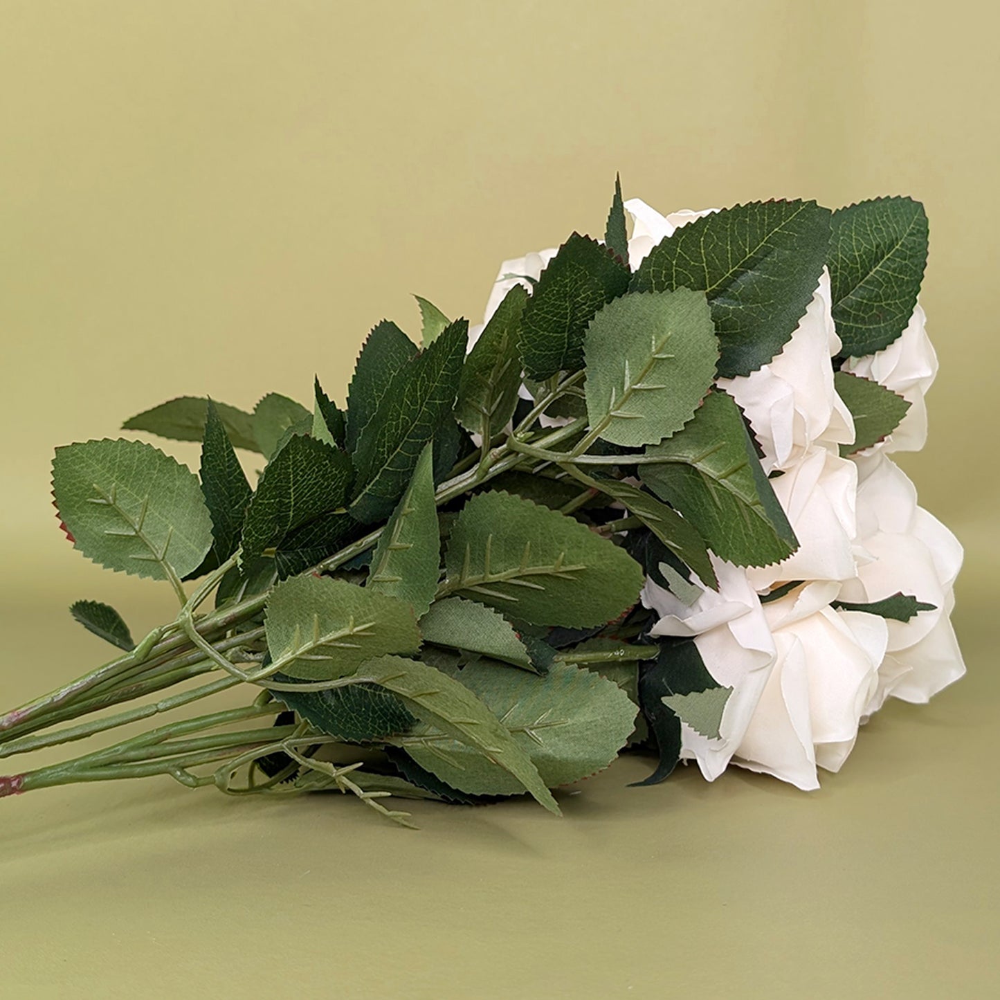 Künstlicher Rosenstrauß mit Blättern und Stielen von hinten fotografiert