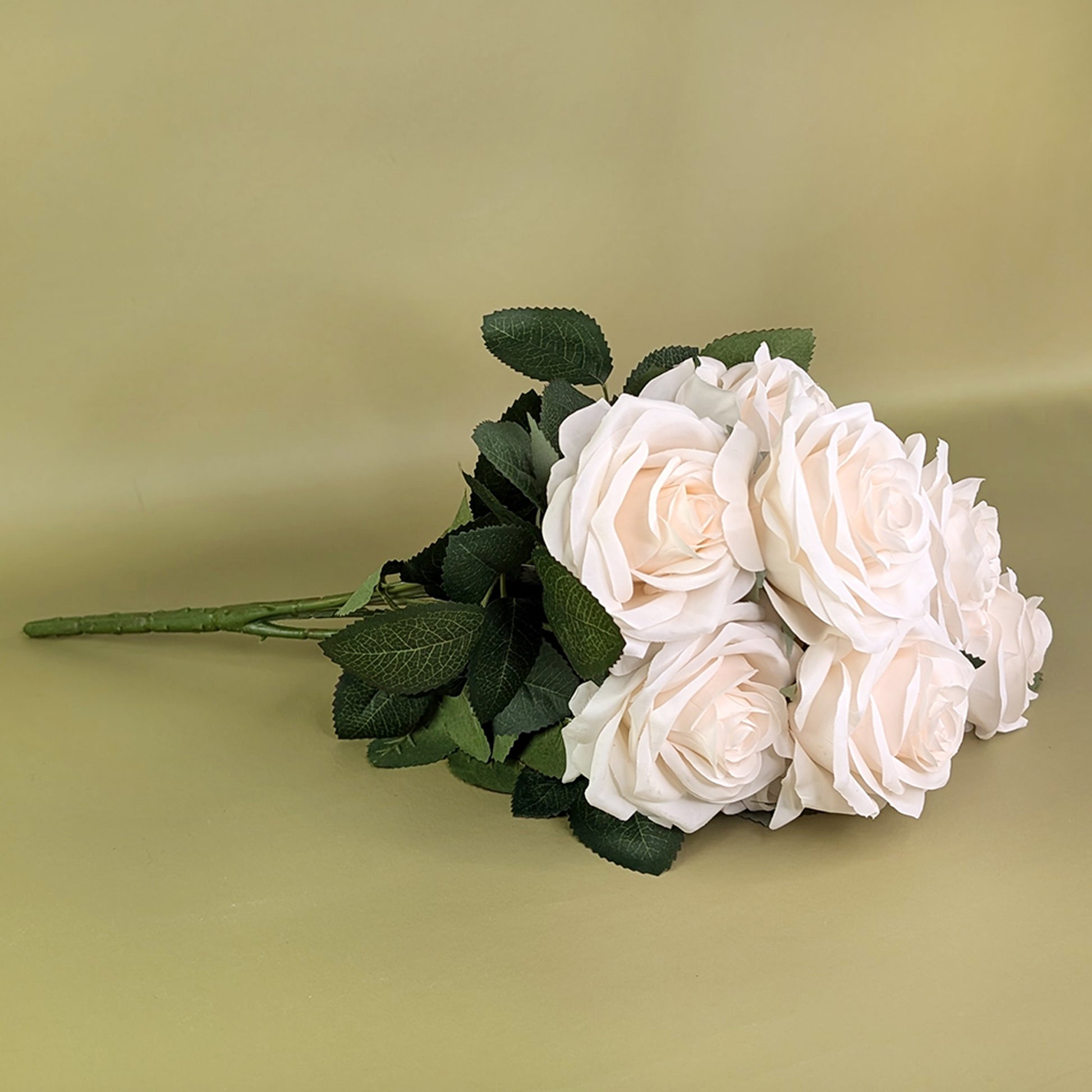 Kunstrosenstrauß seitlich liegend mit weiß-cremefarbenen Blüten und Blättern