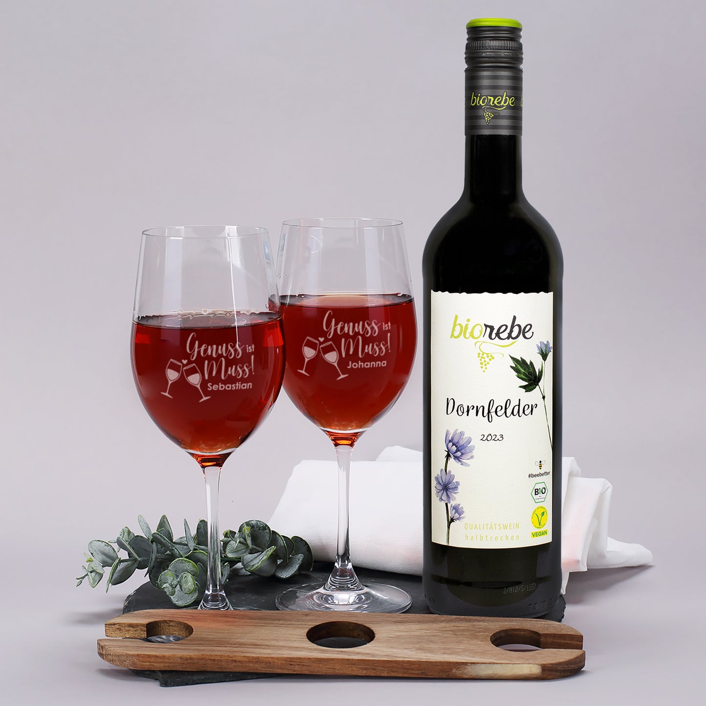 Biorebe Dornfelder mit zwei Weingläsern „Genuss ist Muss“ und Holzhalter auf Schieferplatte dekoriert