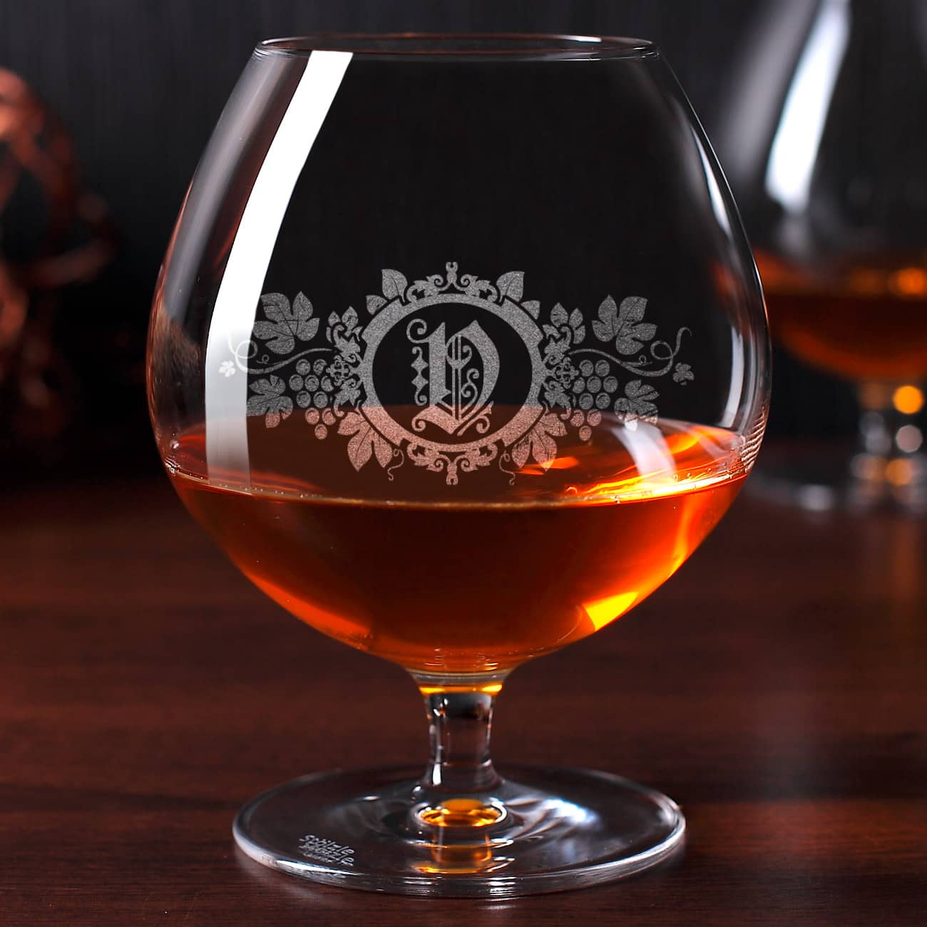 Graviertes Weinbrandglas mit Intiale und Motiv der Weinrebe