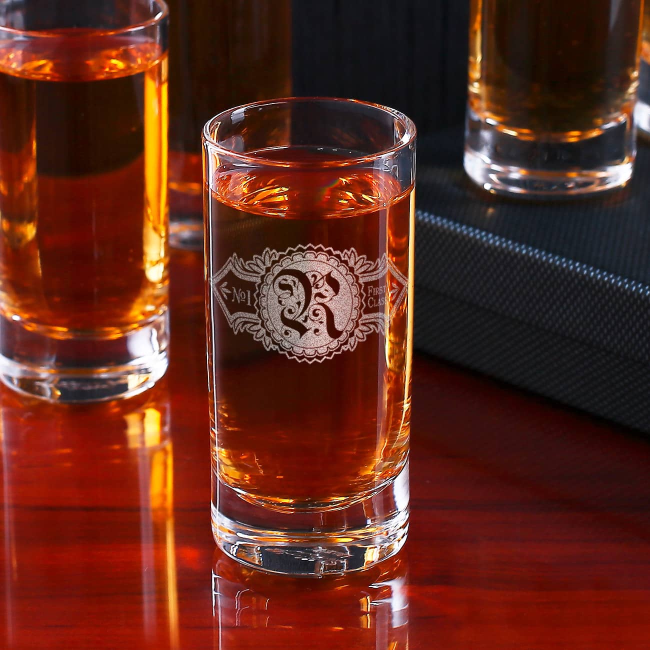 Ihr Initial wird zusammen mit einem nostalgischen Ornament auf das Schnapsglas graviert