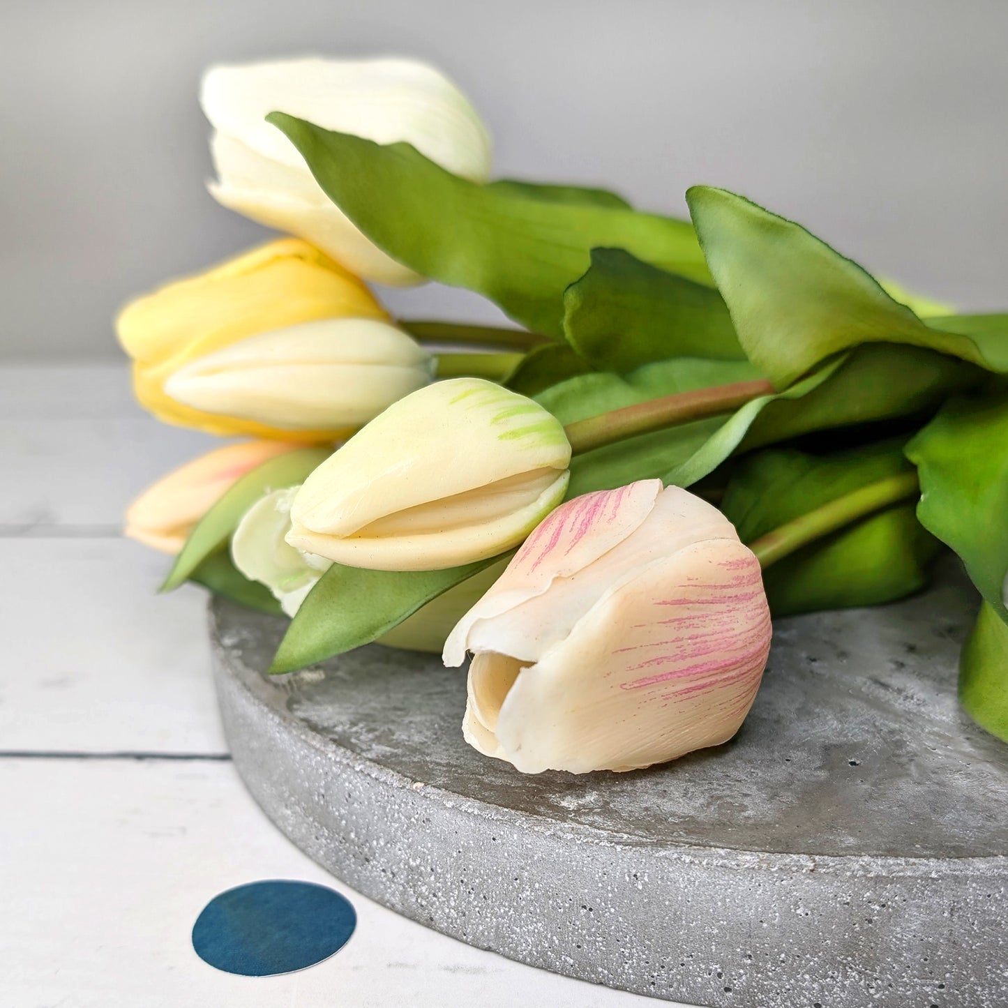 Nahaufnahme der Blüten vom großen Tulpenstrauß „Sally“ auf grauer Platte