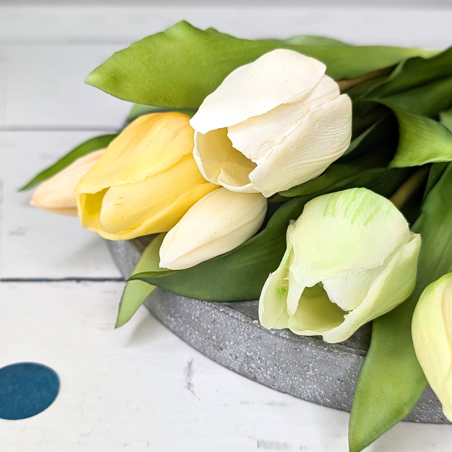 Detailaufnahme von vier hochwertigen Tulpenköpfen in Weiß, Cremegelb, Pastellgrün und zartem Rosa aus recyceltem Seidenmaterial