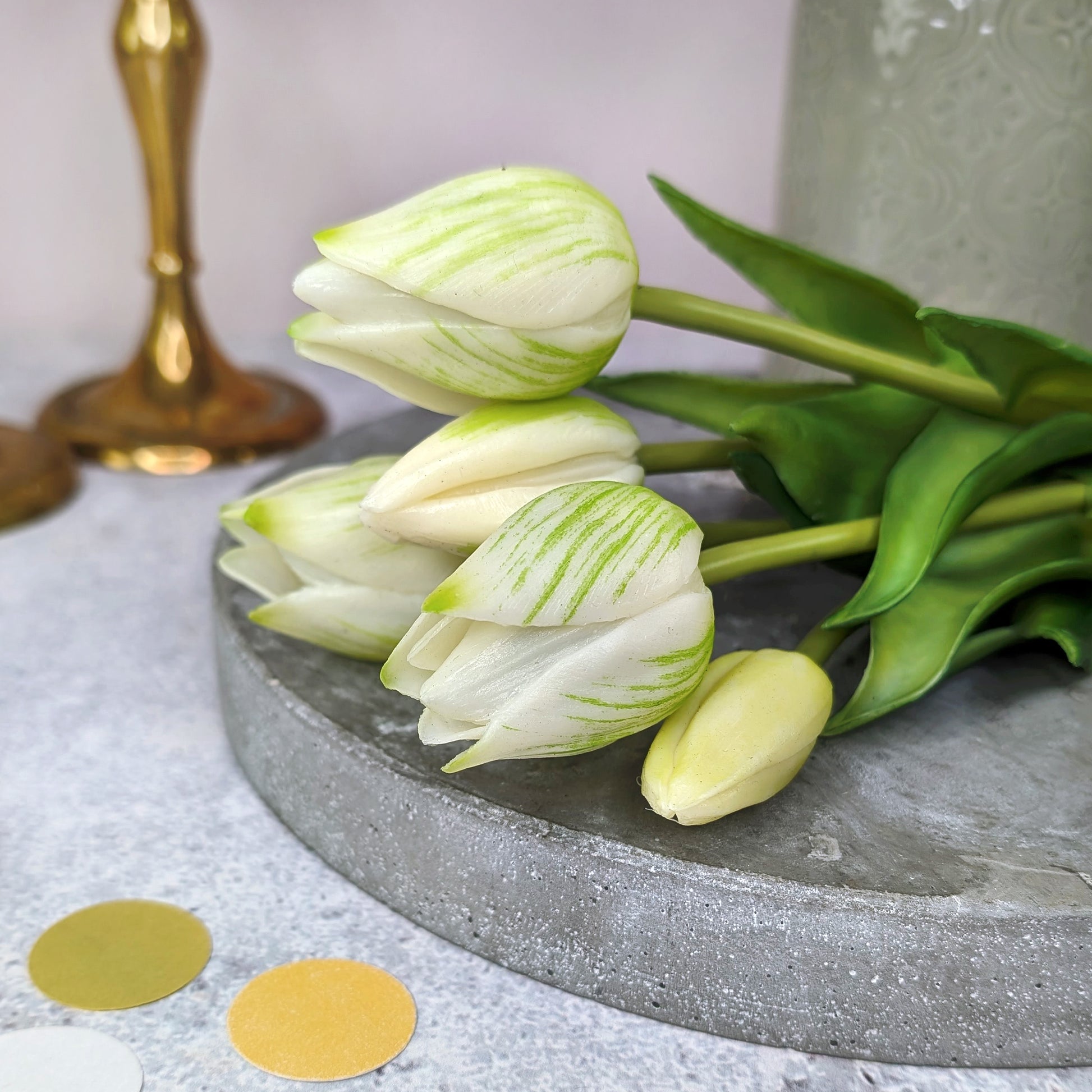 Seitliche Ansicht des kleinen Tulpenstraußes neben Vase und goldenen Kerzenhaltern