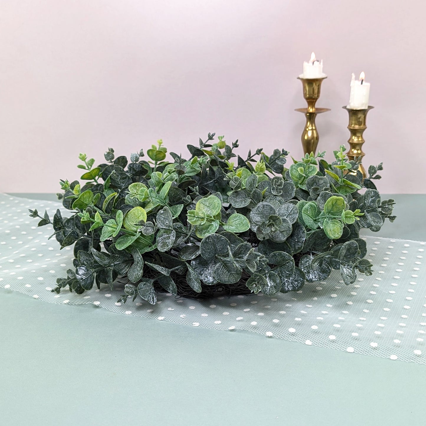 Künstlicher Eukalyptuskranz von der Seite fotografiert mit Kerzen im Hintergrund