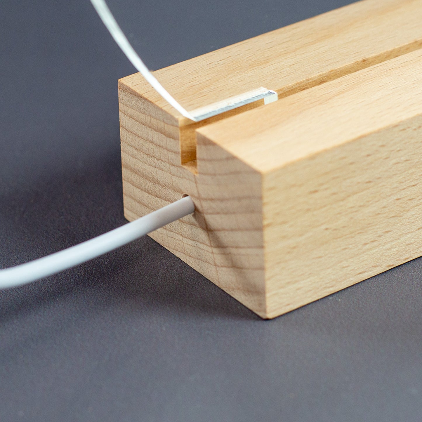 Holzsockel der Acryl-LED-Lampe mit seitlichem Kabelaustritt und eingesetzter Acrylplatte in Detailansicht