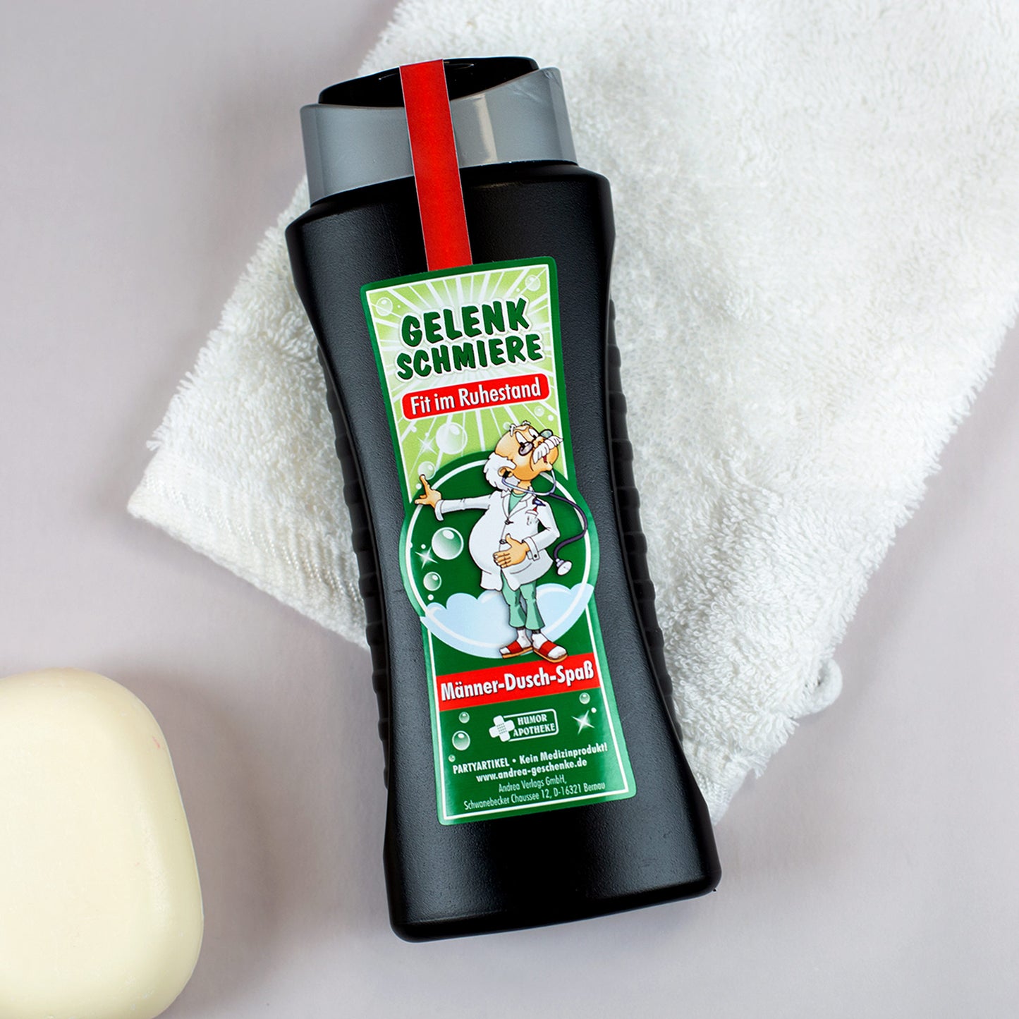 Witziges Männer-Duschgel Gelenkschmiere – Szene mit Handtuch und Seife im Hintergrund