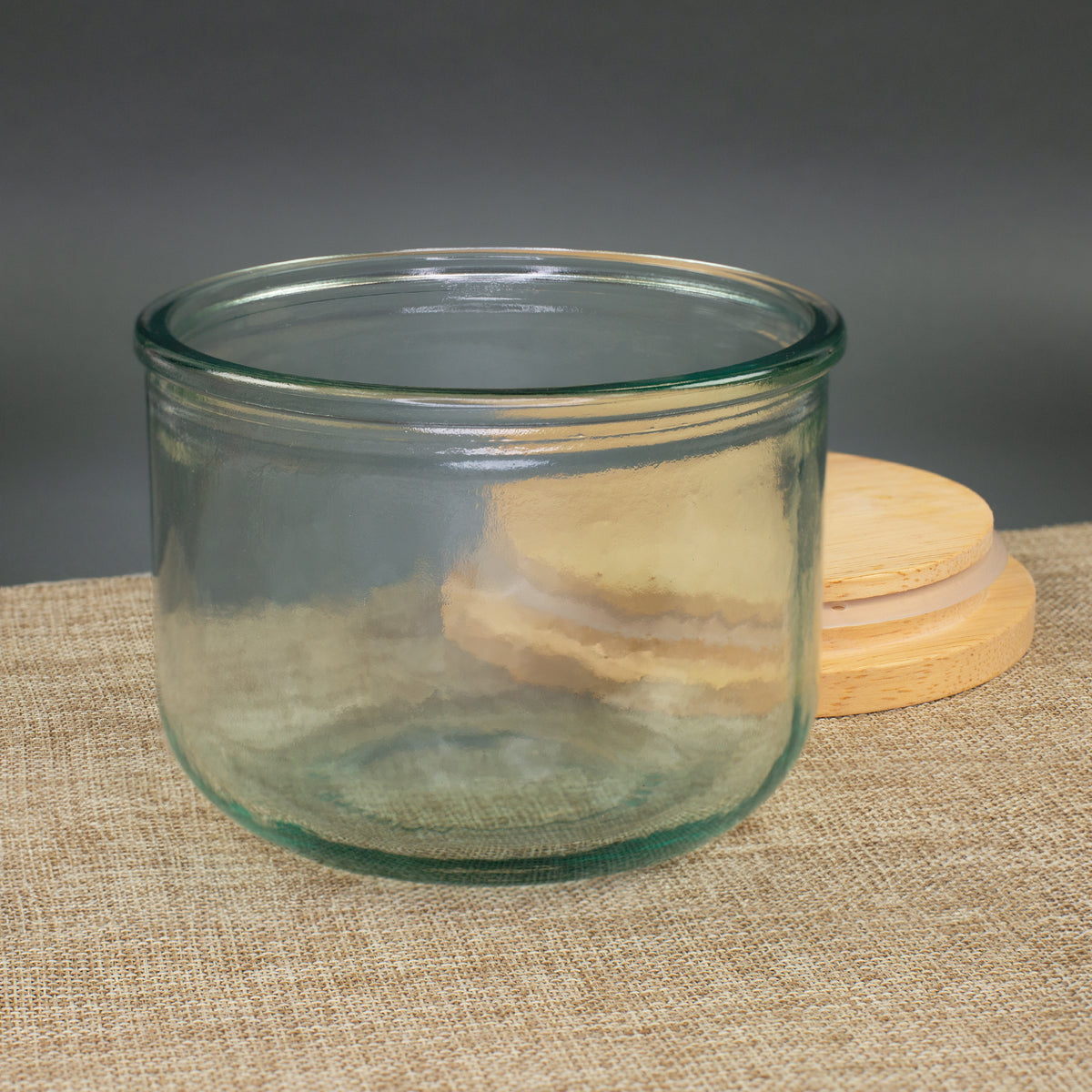 Leeres Vorratsglas aus recyceltem Glas mit abgenommenem Holzdeckel und Silikondichtung