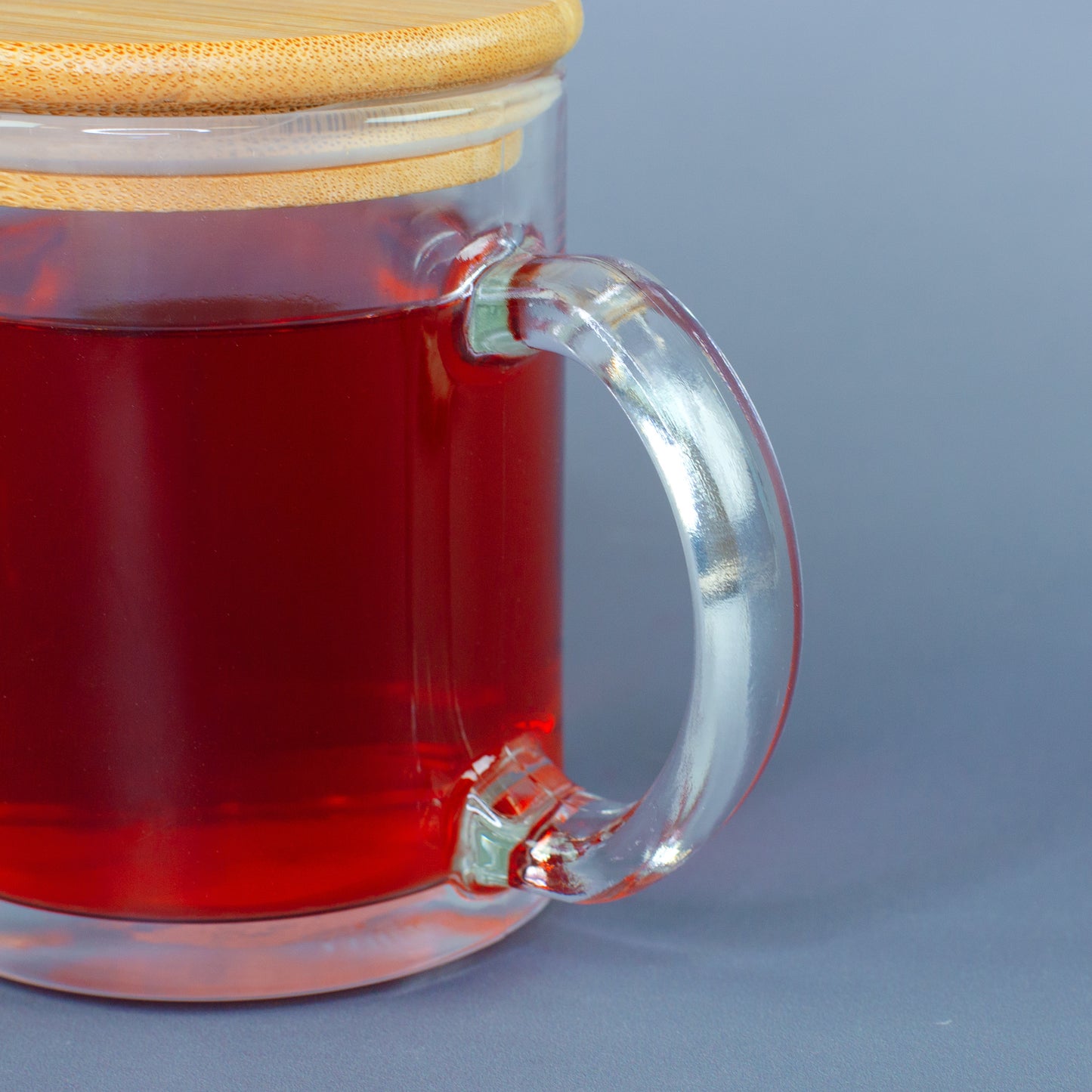 Detailaufnahme vom Henkel der Glastasse mit rotem Tee