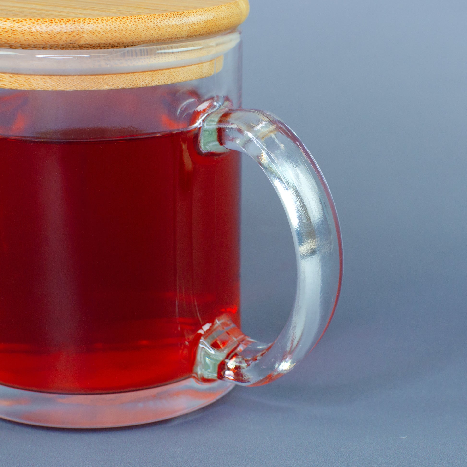 Detailaufnahme vom Henkel der Glastasse mit rotem Tee