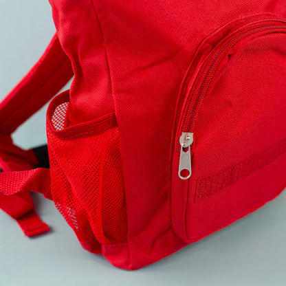 Detailansicht des roten Kinderrucksacks mit Reißverschlussfach und seitlichem Netzfach
