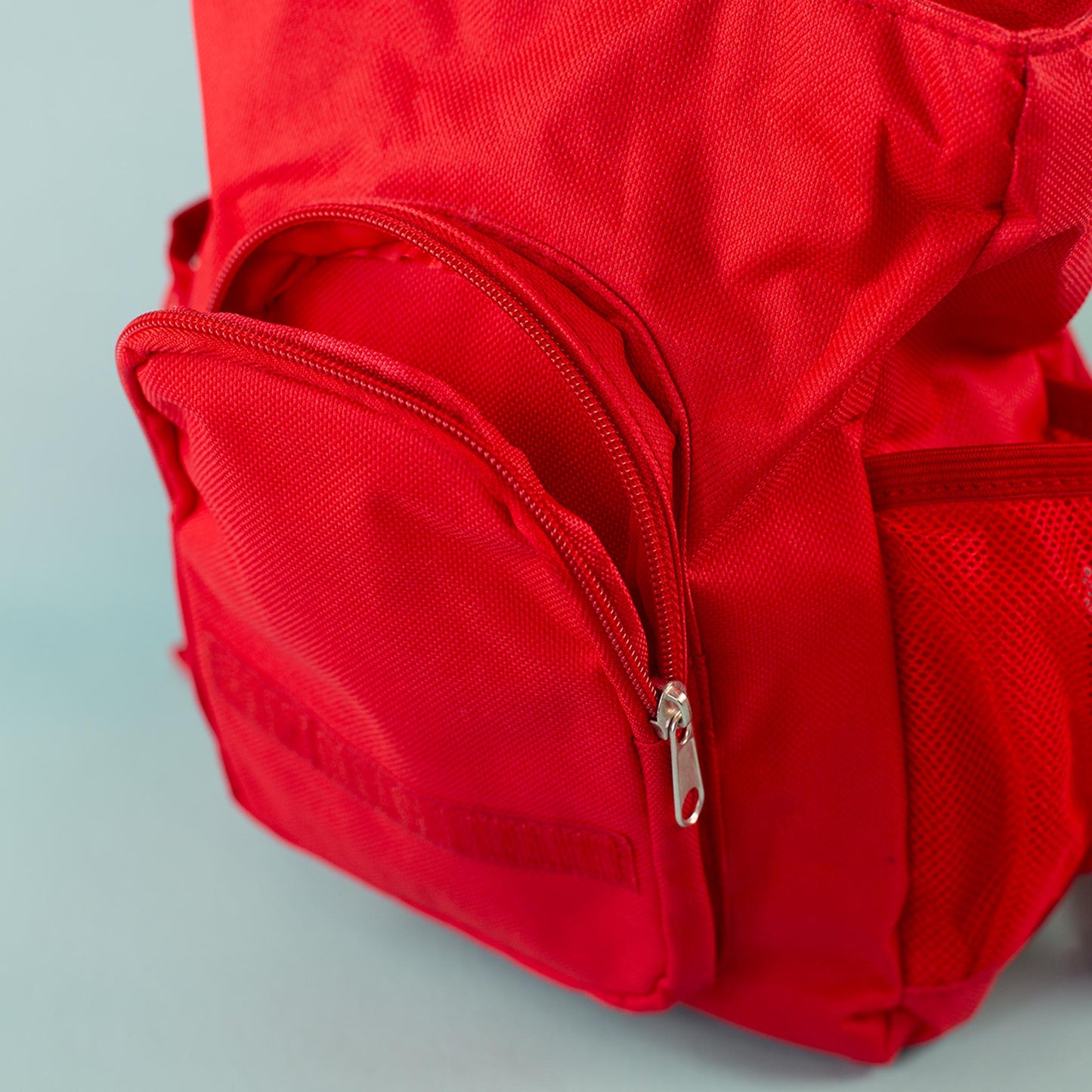 Detailbild der Außentasche mit Reißverschluss am roten Kinderrucksack