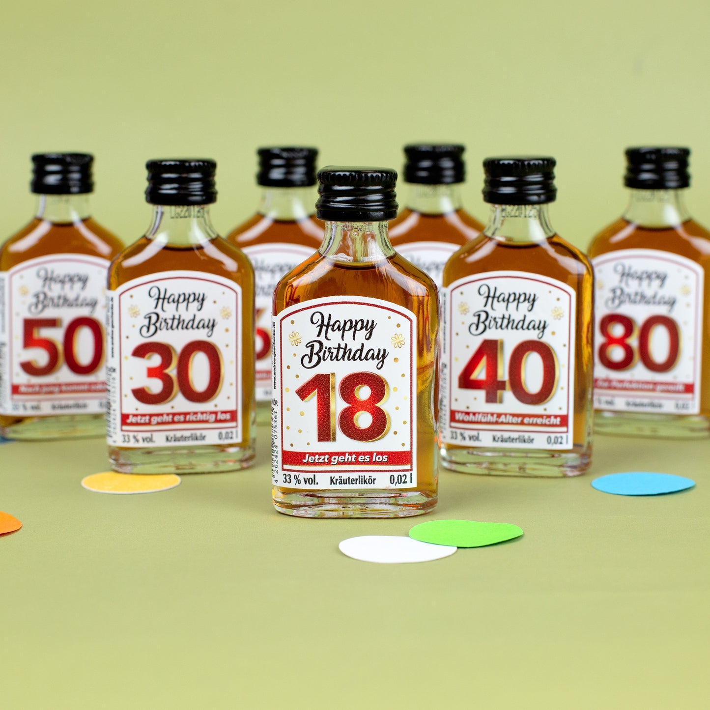 Miniatur-Kräuterlikörflasche „Happy Birthday 18“ vorne, dahinter weitere Flaschen mit Geburtstagszahlen 30, 40, 50, 70 und 80