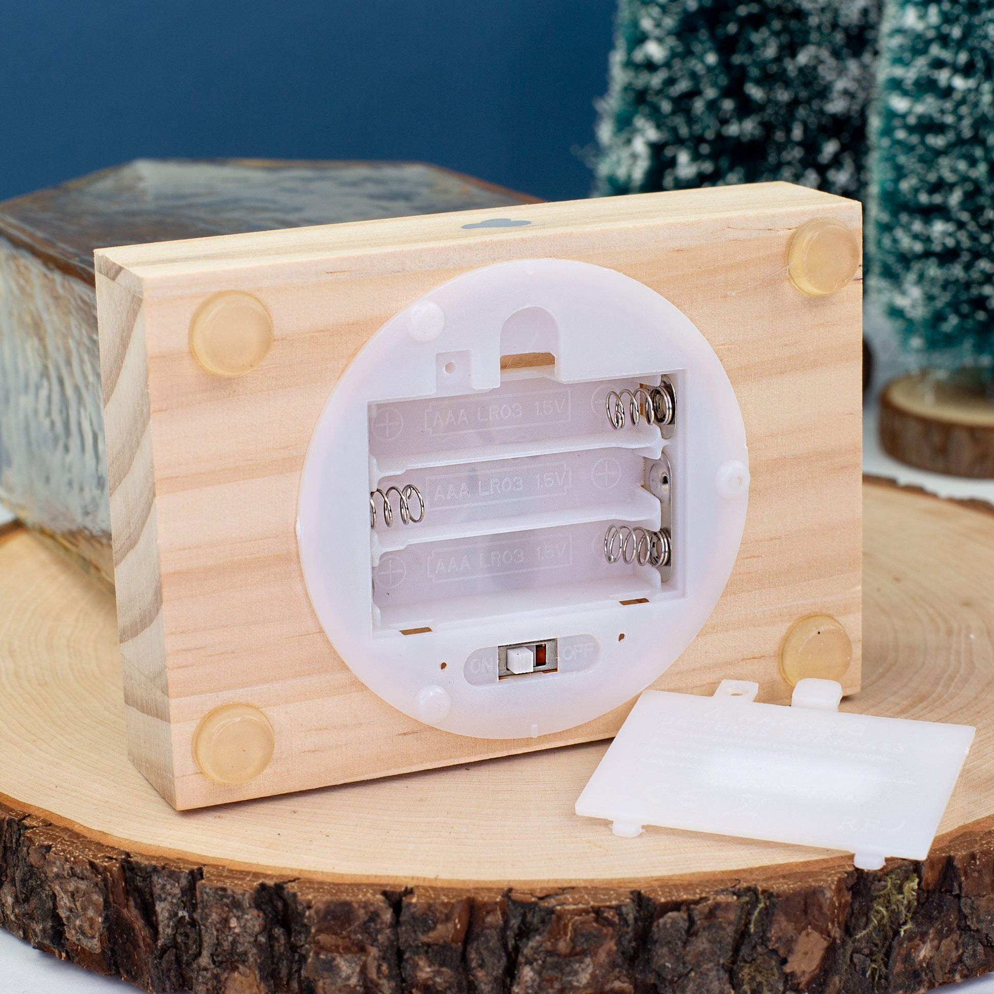 Offenes Batteriefach des LED-Hauses von Leonardo mit Platz für drei AAA-Batterien – Detailaufnahme des Holzsockels.