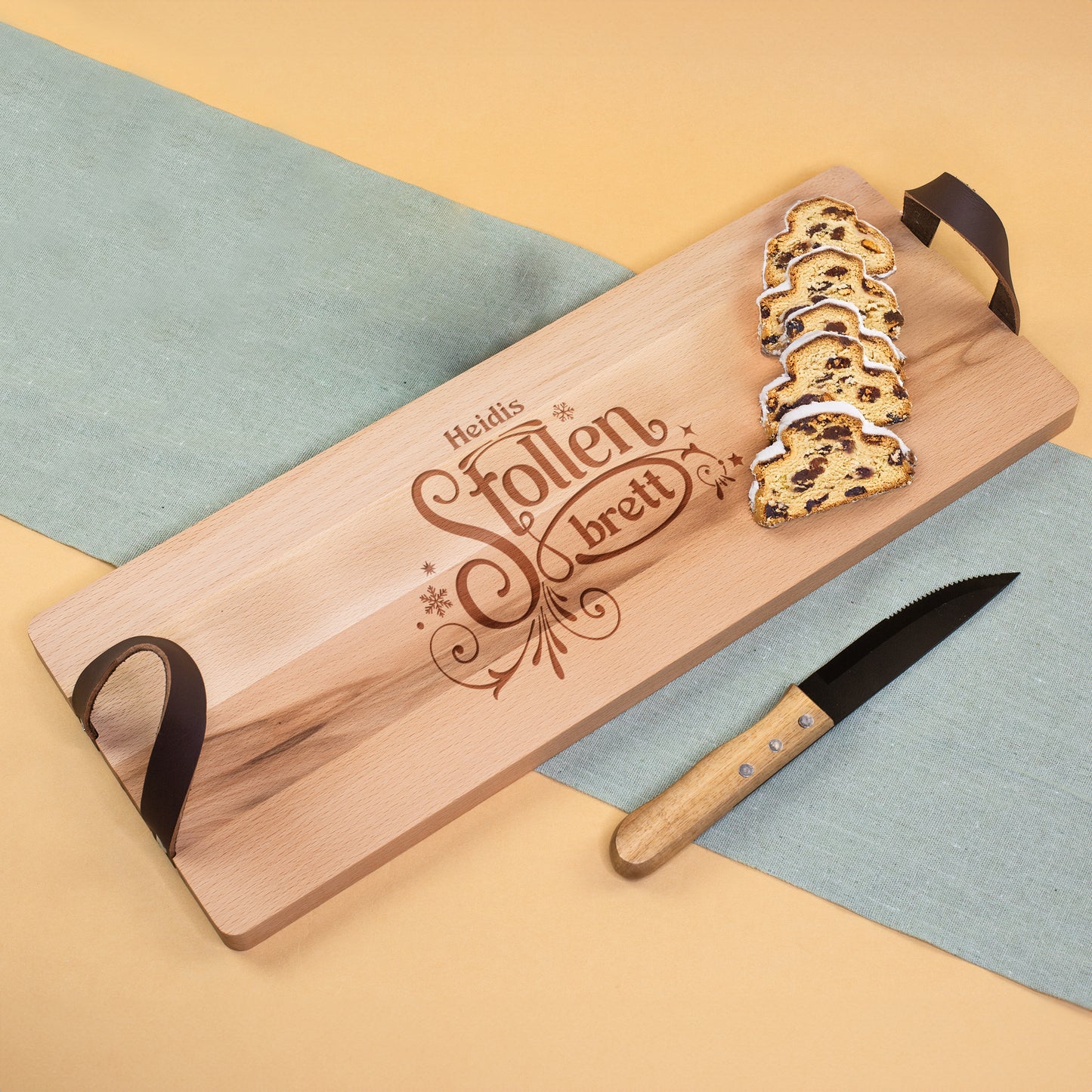 Stollenbrett mit Namensgravur und Ledergriffen, serviert mit angeschnittenem Christstollen