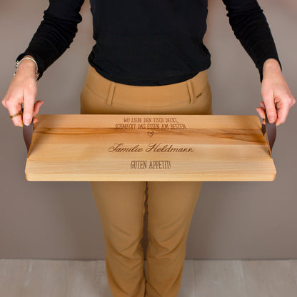 Person hält Servierbrett aus Buchenholz mit Ledergriffen und personalisierter Gravur