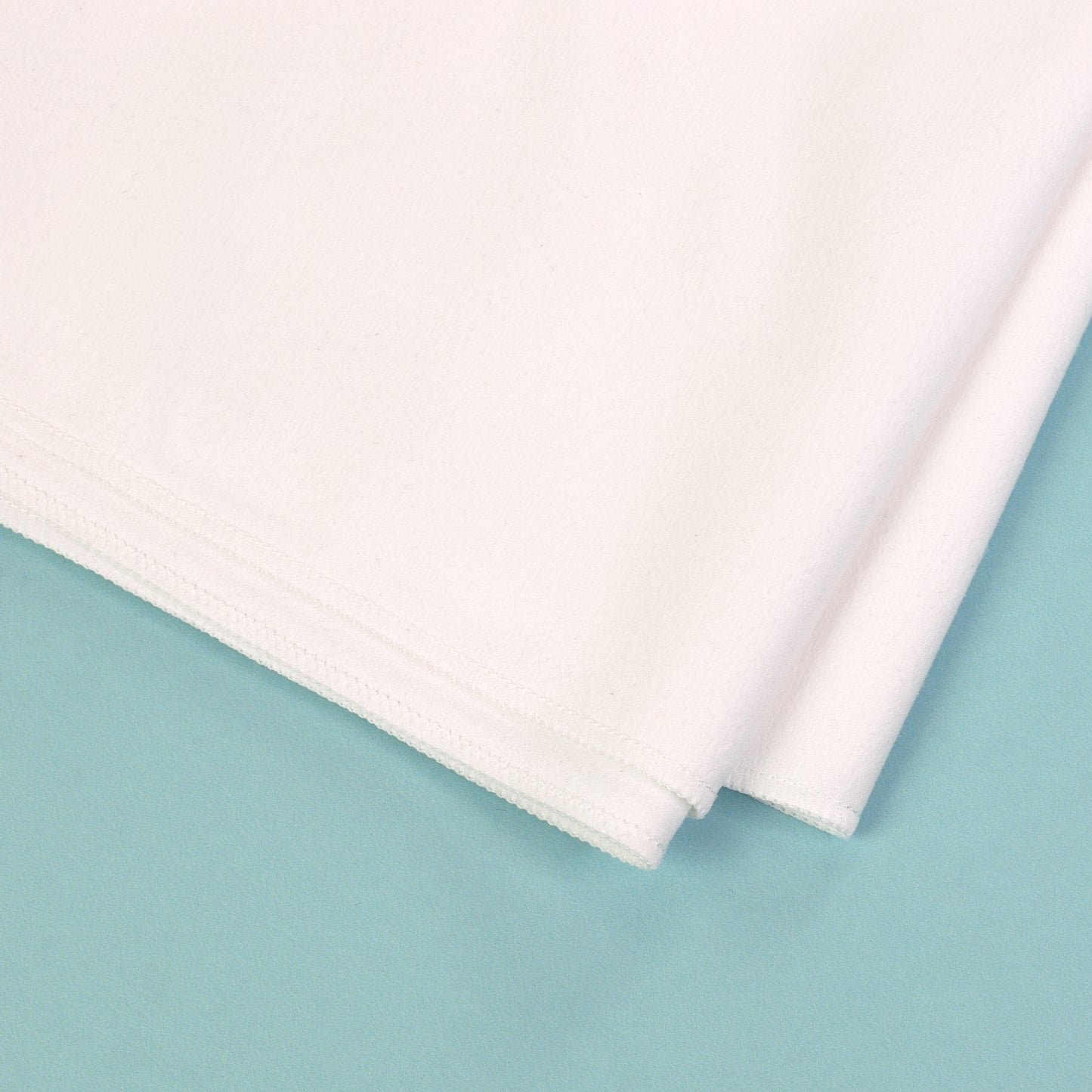 Detailaufnahme von Material und Naht eines weißen Sporthandtuchs