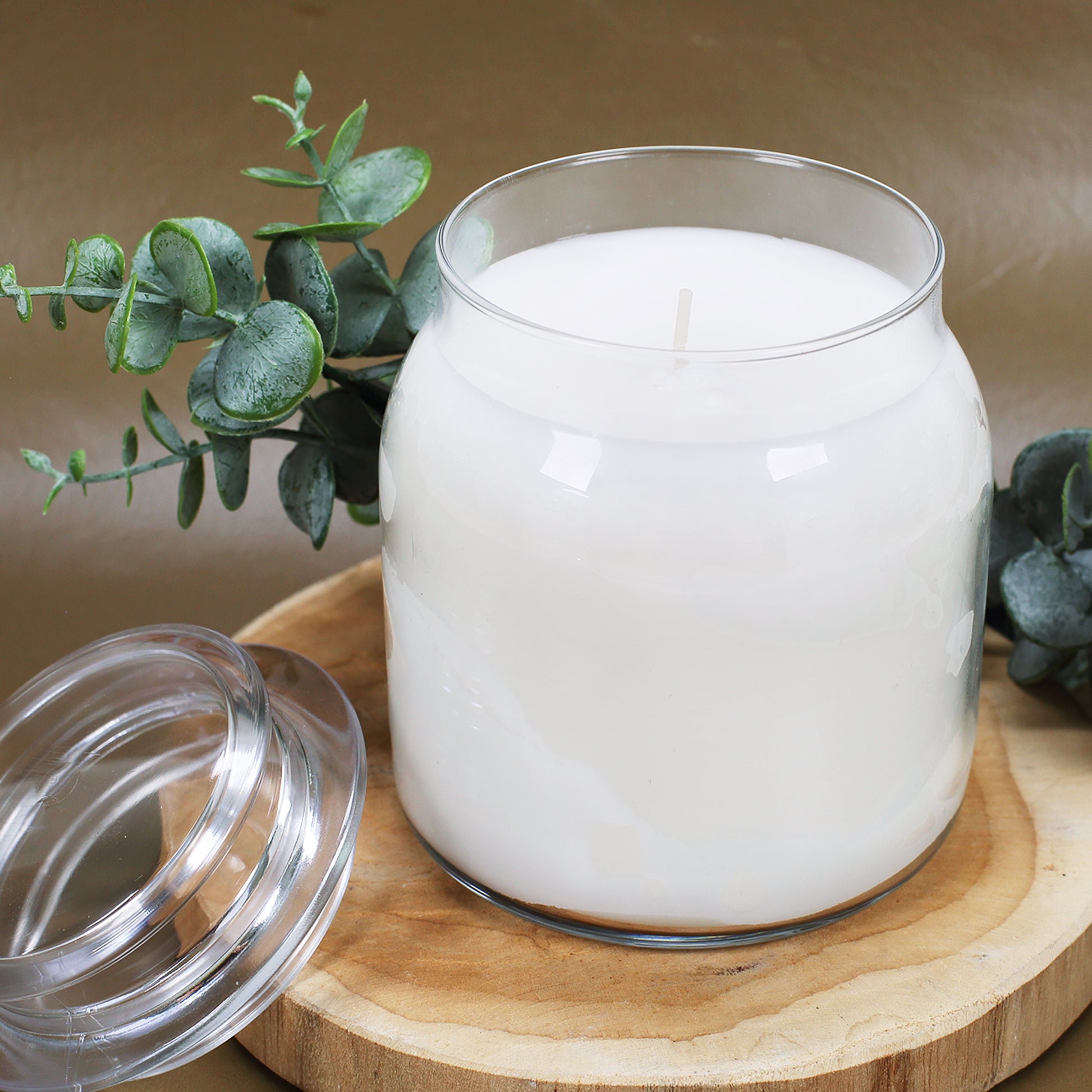 Duftkerze als dekoratives Geschenk für Verliebte auf Holzscheibe arrangiert