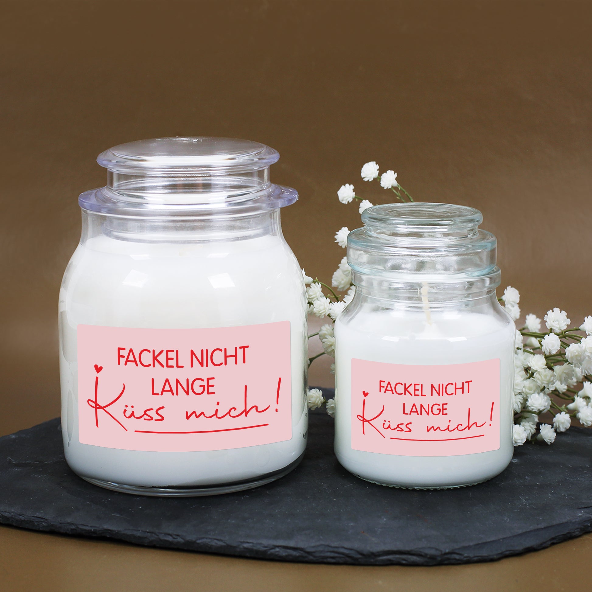 Großes und kleines Kerzenglas mit weißem Wachs und romantischem Valentinstagsdesign