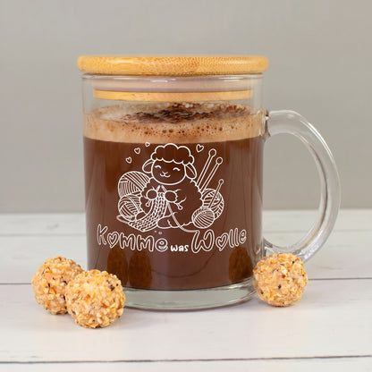 Glastasse mit Bambusdeckel, Kakao und weißem Schaf-Strickmotiv „Komme was Wolle“ mit Wollknäueln