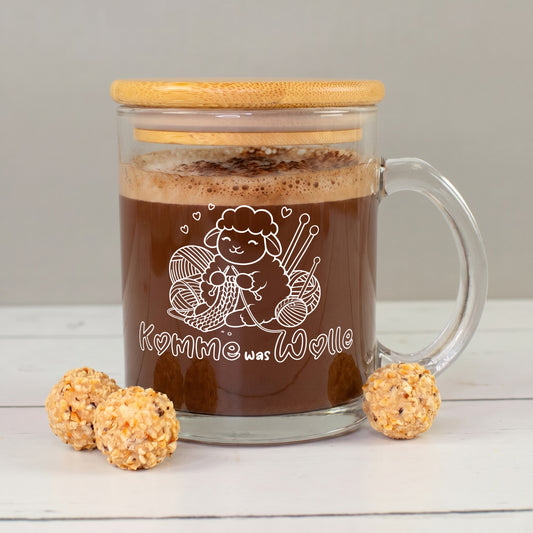 Glastasse mit Bambusdeckel, Kakao und weißem Schaf-Strickmotiv „Komme was Wolle“ mit Wollknäueln