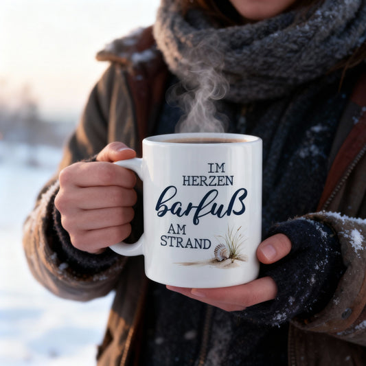 Tasse „Im Herzen barfuß am Strand“ in winterlicher Umgebung mit heißem Getränk
