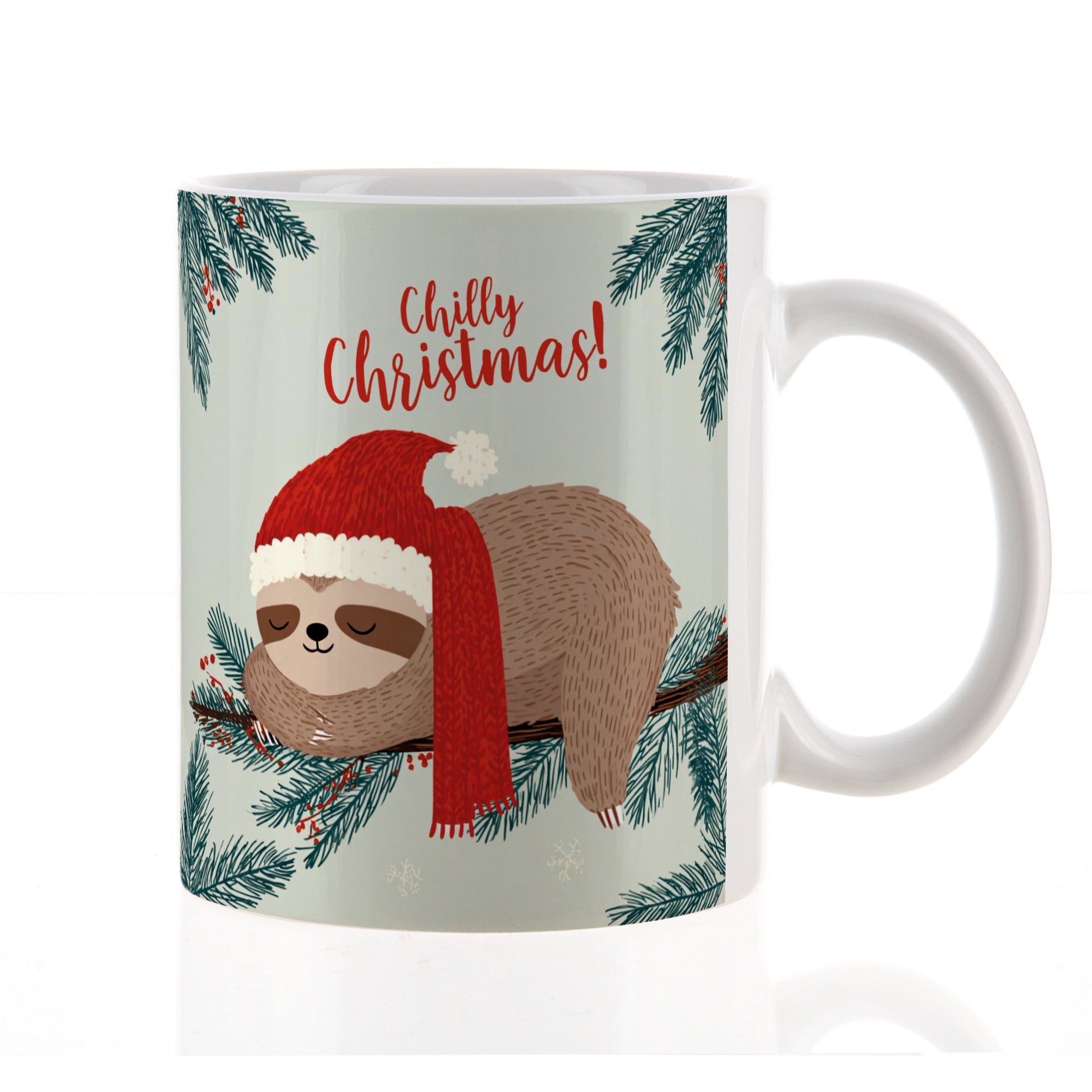 Freigestellte Keramiktasse mit Faultier in Weihnachtsmütze und Schal auf Tannenzweig, Text „Chilly Christmas!“ – neutrale Studioaufnahme.

