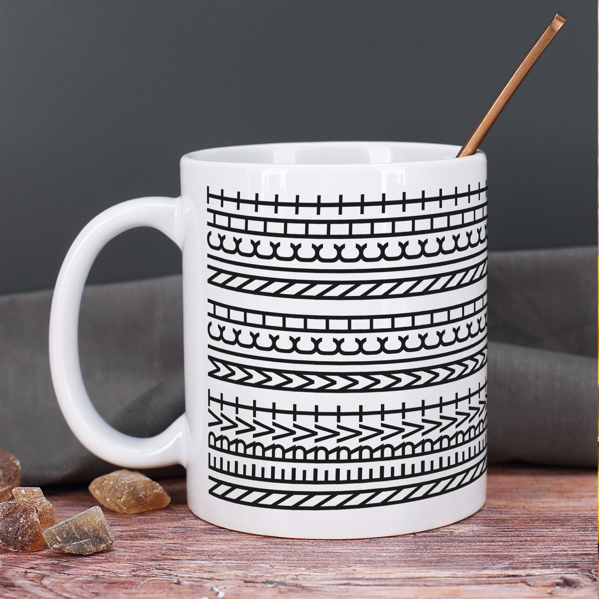 Keramiktasse mit modernem Muster auf rustikalem Holztisch mit einem Löffel innen