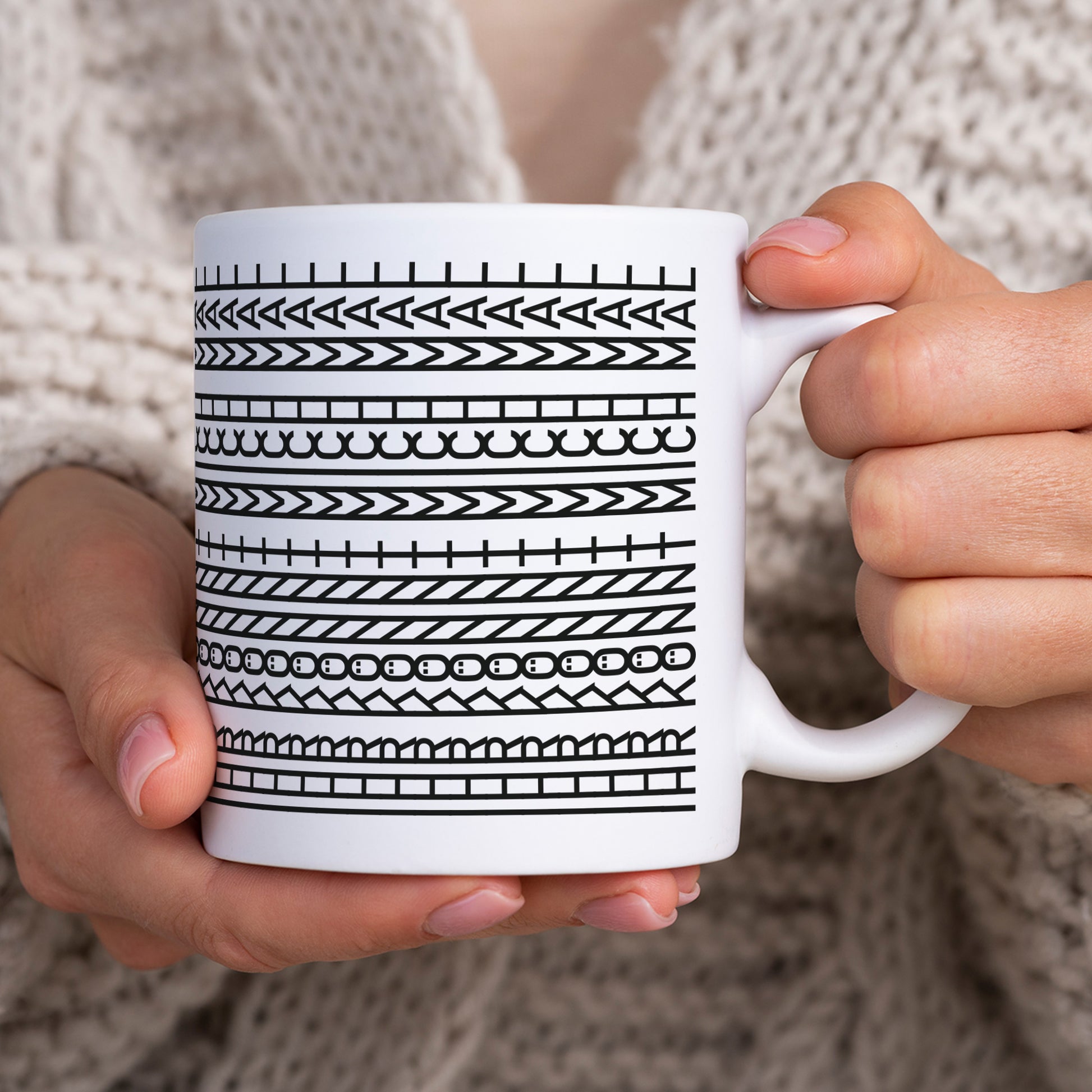 Lustige Tasse mit Schwarz-Weiß-Muster wird in beiden Händen gehalten