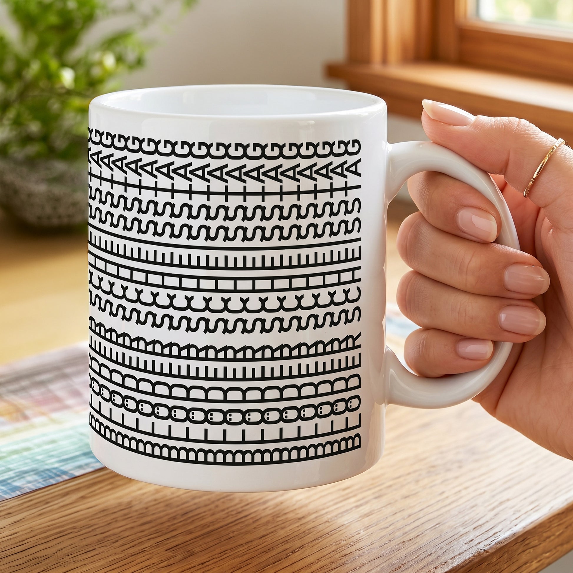 Tasse mit grafischem Schwarz-Weiß-Motiv und versteckter Botschaft „Blöder Scheißtag“ in einer Hand gehalten