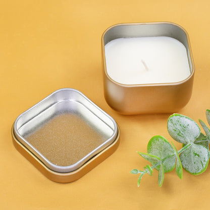 Goldene Metallkerze mit abgenommenem Deckel neben Eukalyptuszweig