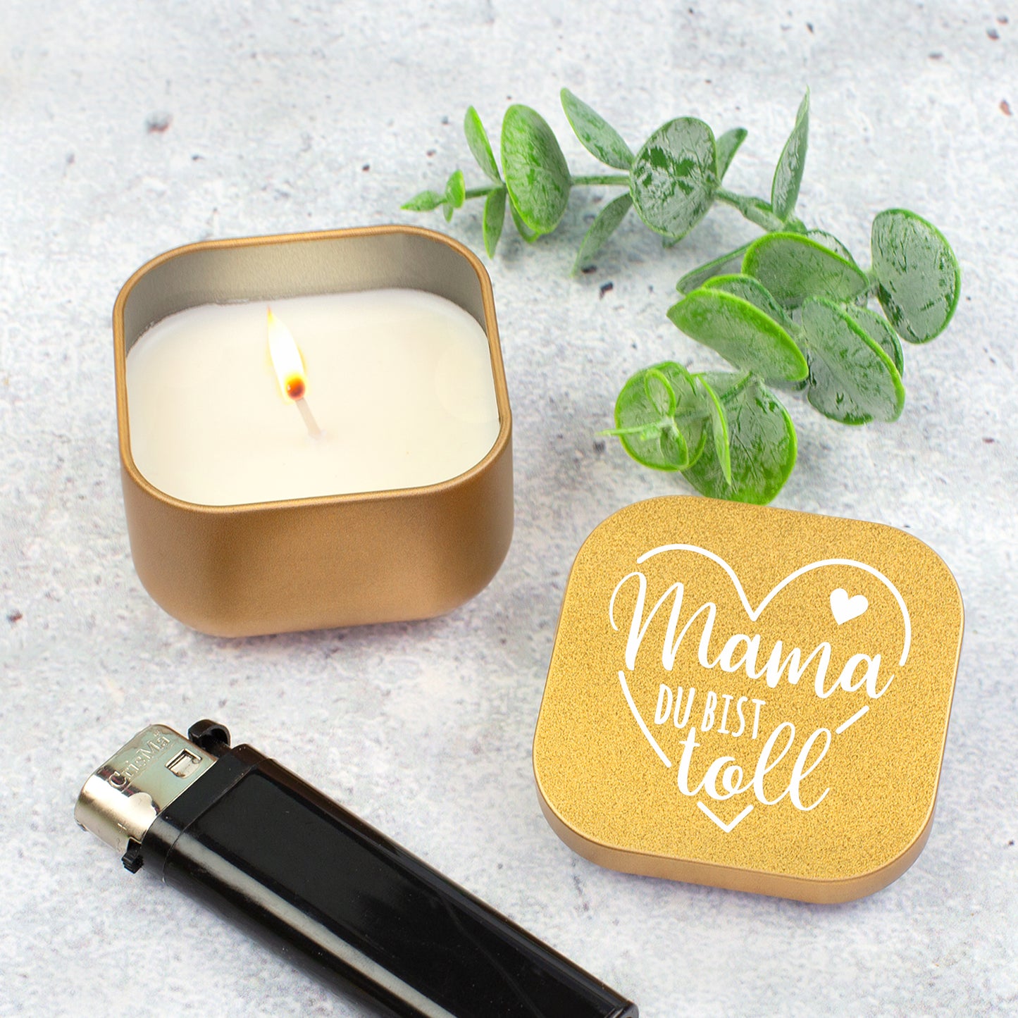 Goldene Duftkerze „Mama du bist toll“ geöffnet mit Feuerzeug und Eukalyptus