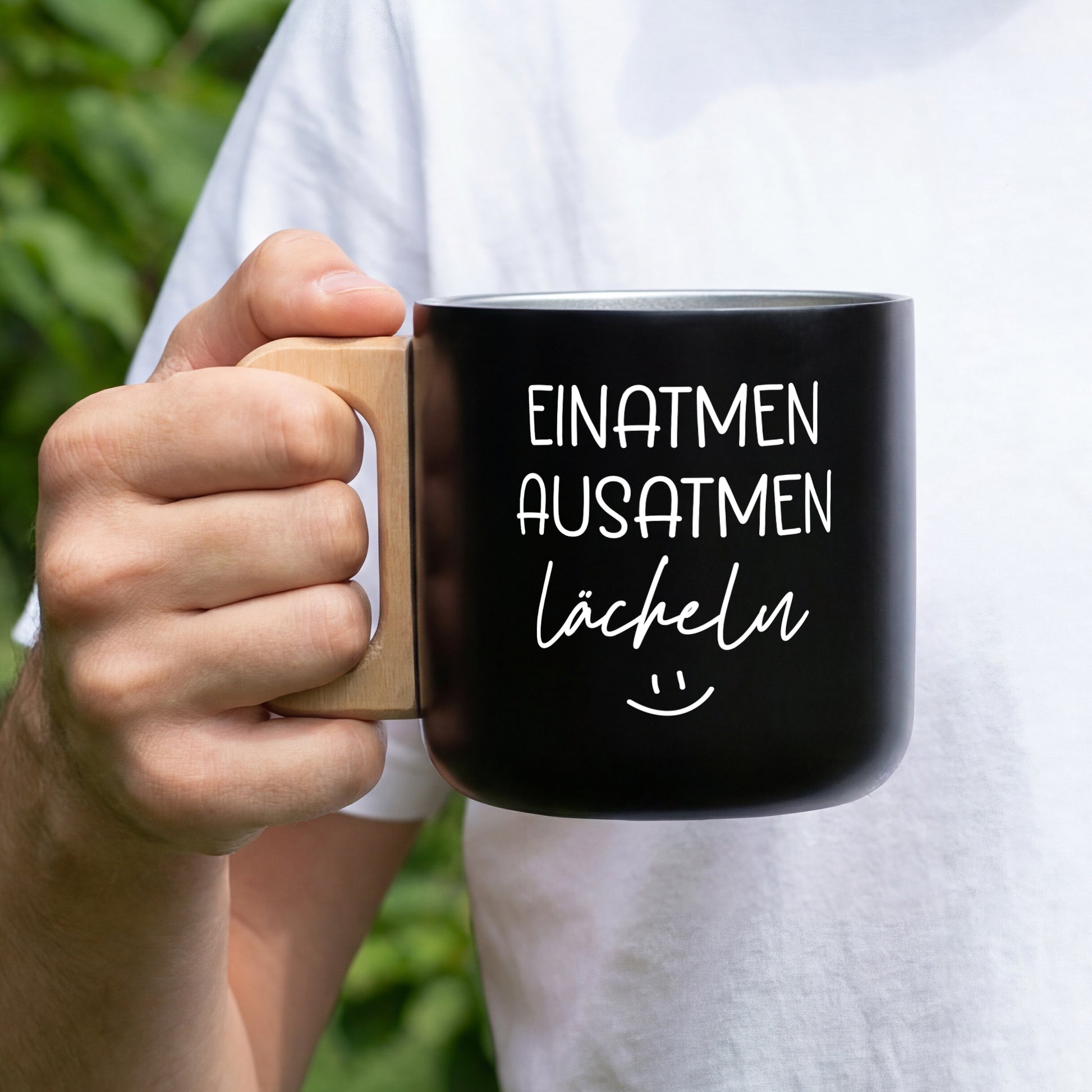 Schwarzer Edelstahlbecher mit Holzgriff und weißem Spruch Einatmen Ausatmen Lächeln