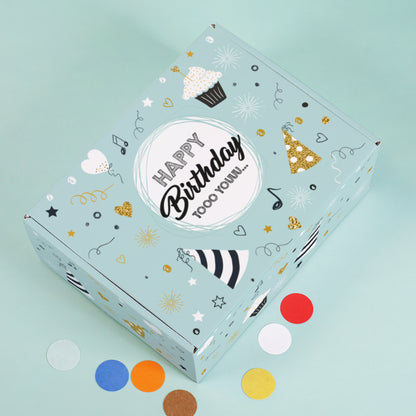 Obenansicht der Geburtstagsbox mit Konfetti auf türkisfarbenem Untergrund und goldenen Details