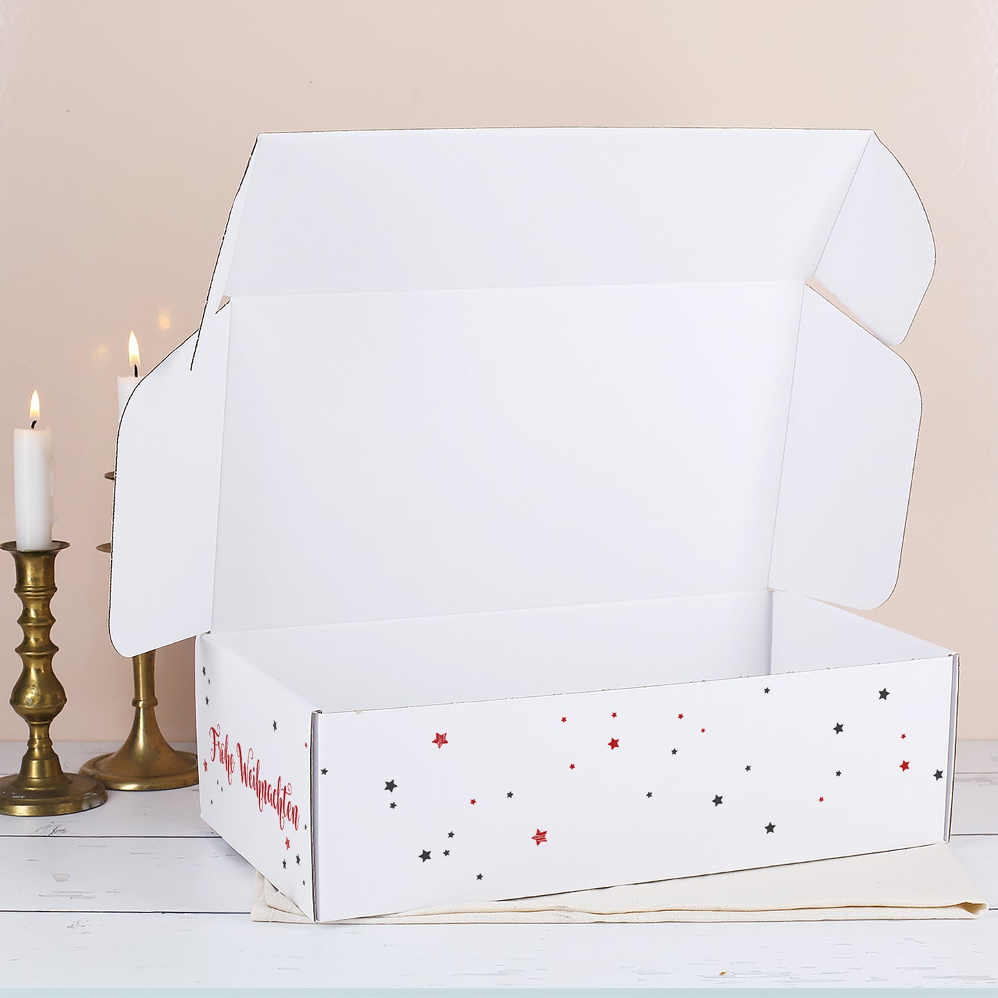 Geöffnete weiße Weihnachtsbox mit rotem und schwarzem Sternenmuster sowie schlichtem weißem Innenraum