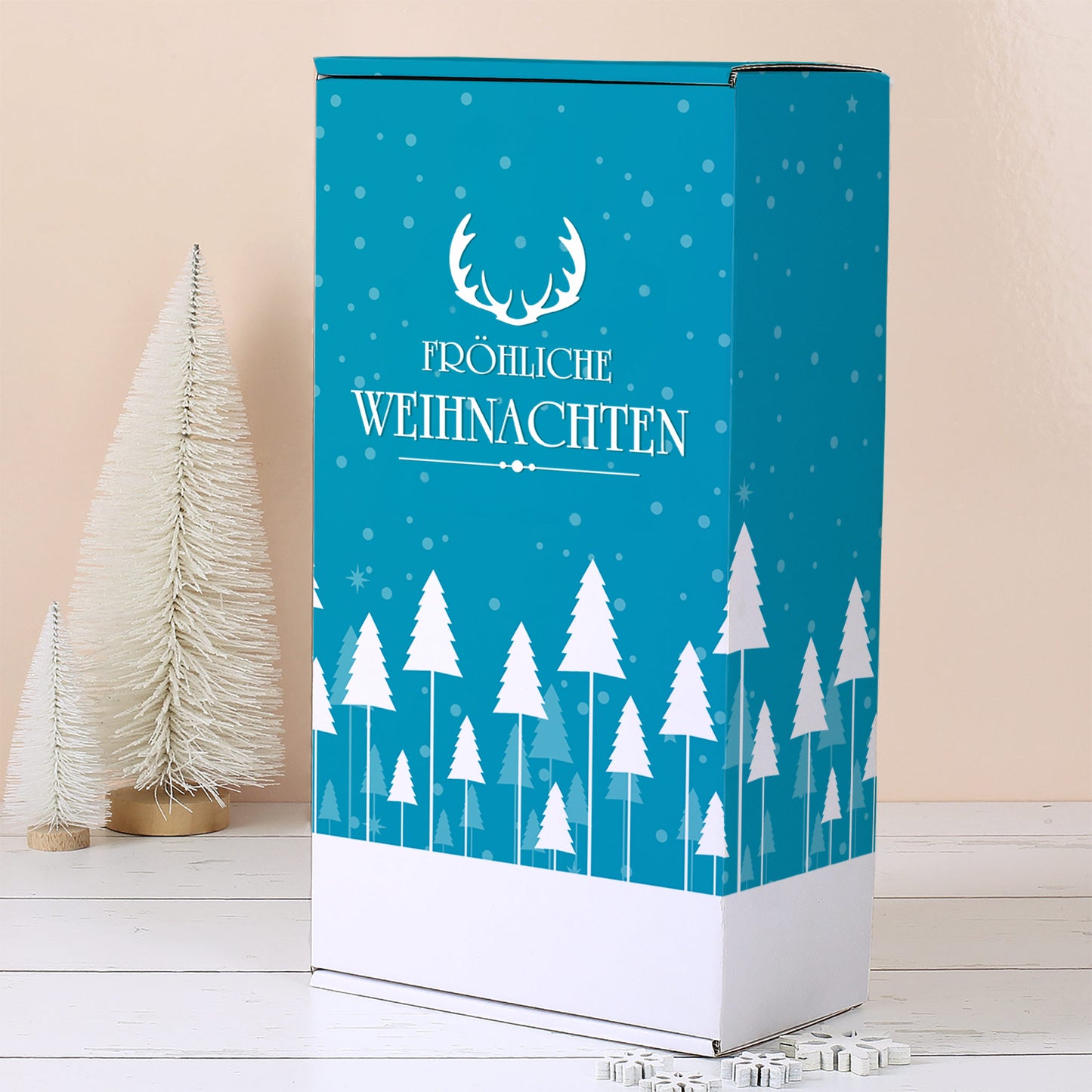 Aufrecht stehende türkise Geschenkbox mit weißem Winterwald, Schneeflocken, Geweih Motiv und Fröhliche Weihnachten Schriftzug