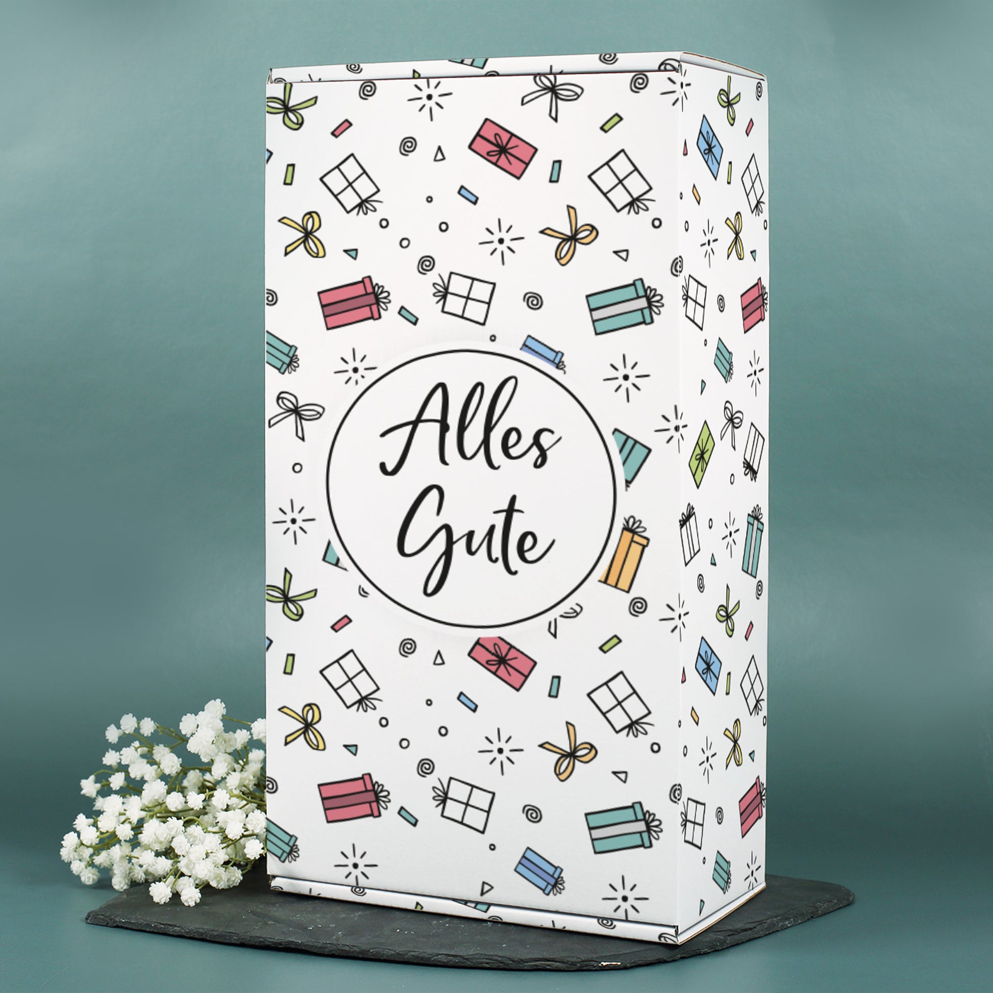Große Geschenkverpackung „Alles Gute“ mit floraler Deko auf grauem Untergrund