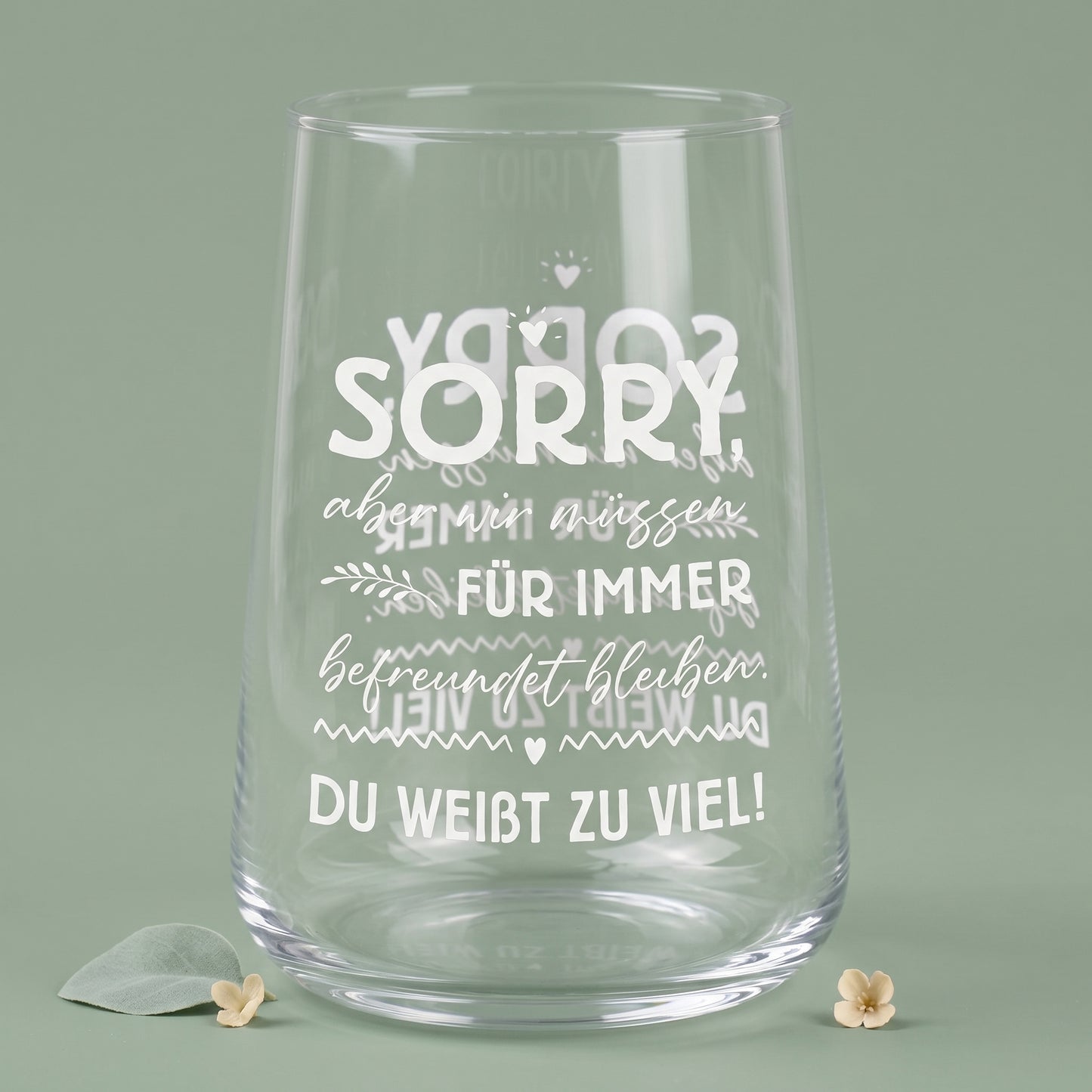Leeres transparentes Trinkglas mit weißem Motivdruck und sichtbarer Spiegelung des Spruchs