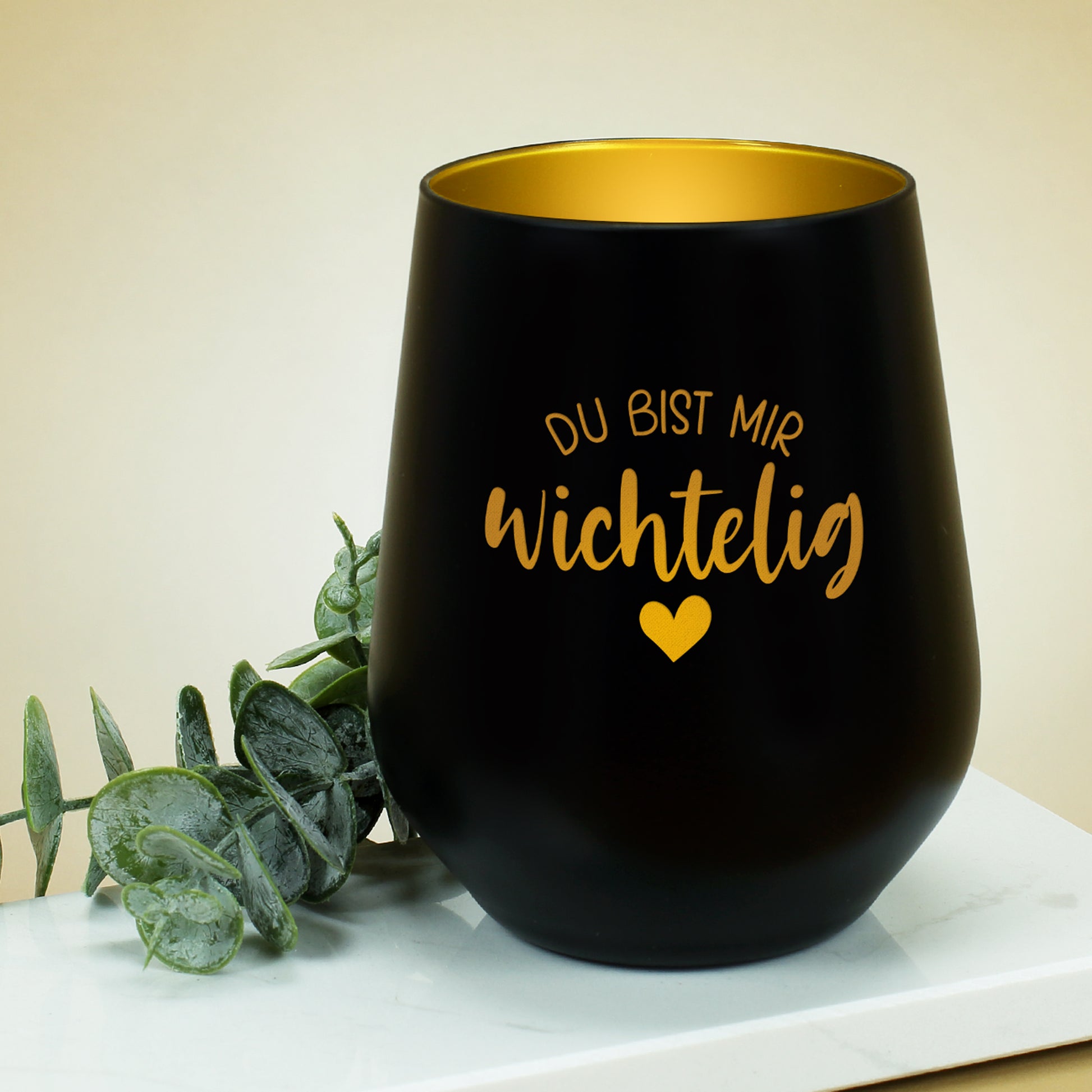 Schwarzes Wichtelig-Windlicht auf hellem Untergrund mit goldschimmernder Innenbeschichtung