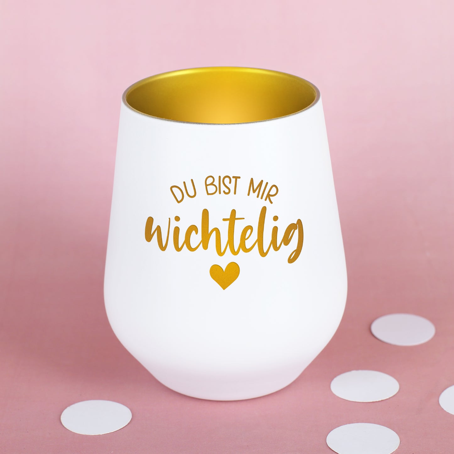 Weißes Windlicht mit goldener Innenfläche und Wichtelig-Motiv auf rosa Hintergrund