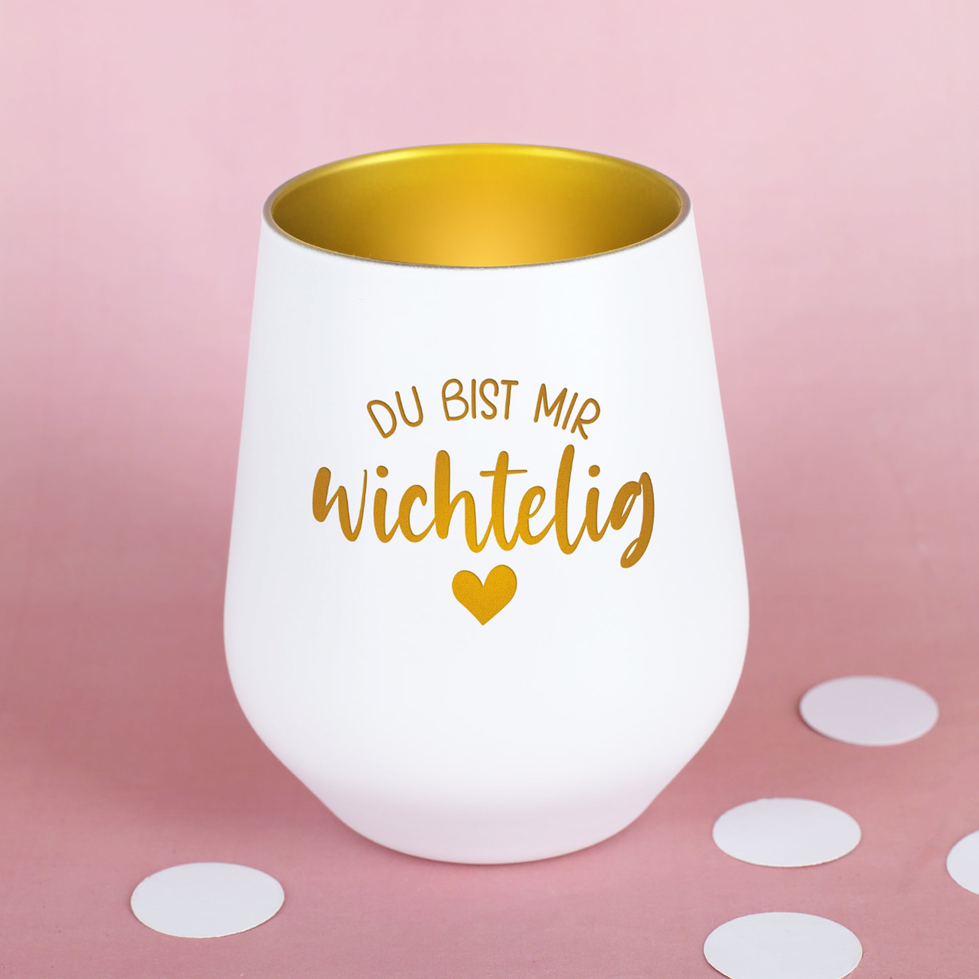 Weißes Windlicht mit goldener Innenfläche und Wichtelig-Motiv auf rosa Hintergrund